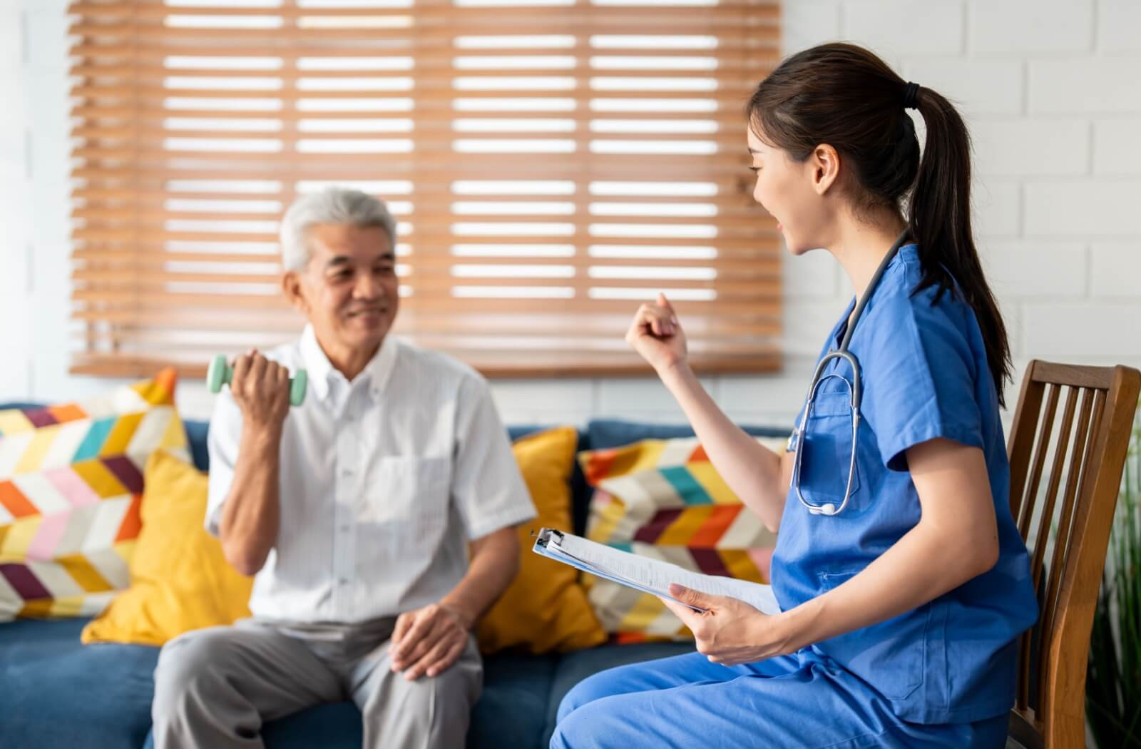 An older adult uses light weights while seated to strengthen the core and promote balance during an OT session.