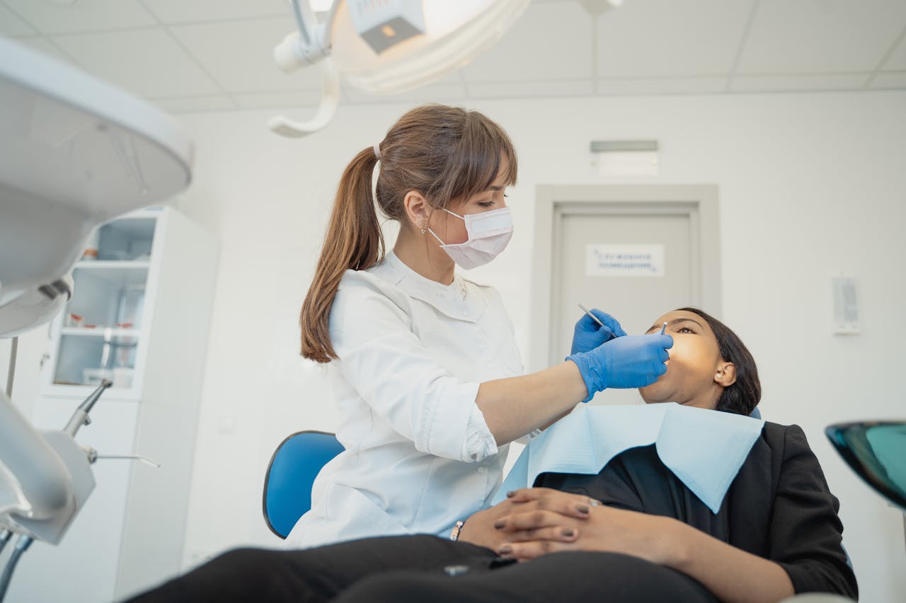 Dentista olhando a boca da paciente, mantendo os cuidados bucais durante a radioterapia.