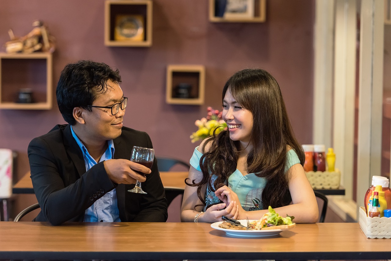 A couple sitting at a counter engaged in conversation. 