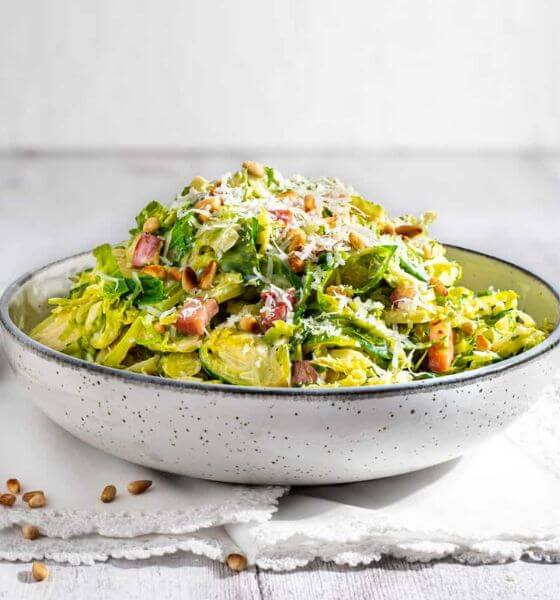 Creamy brussels sprouts in white and black speckled bowl