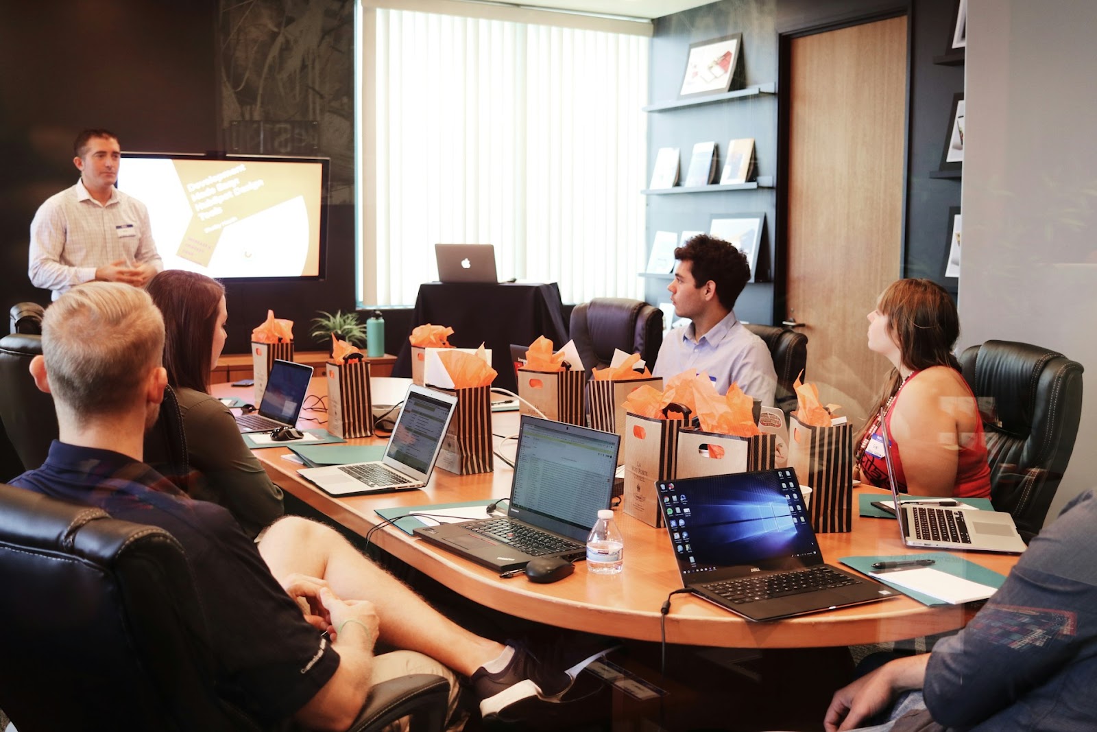 A diverse group of people gathered around a table, focused on their laptops, collaborating and sharing ideas.