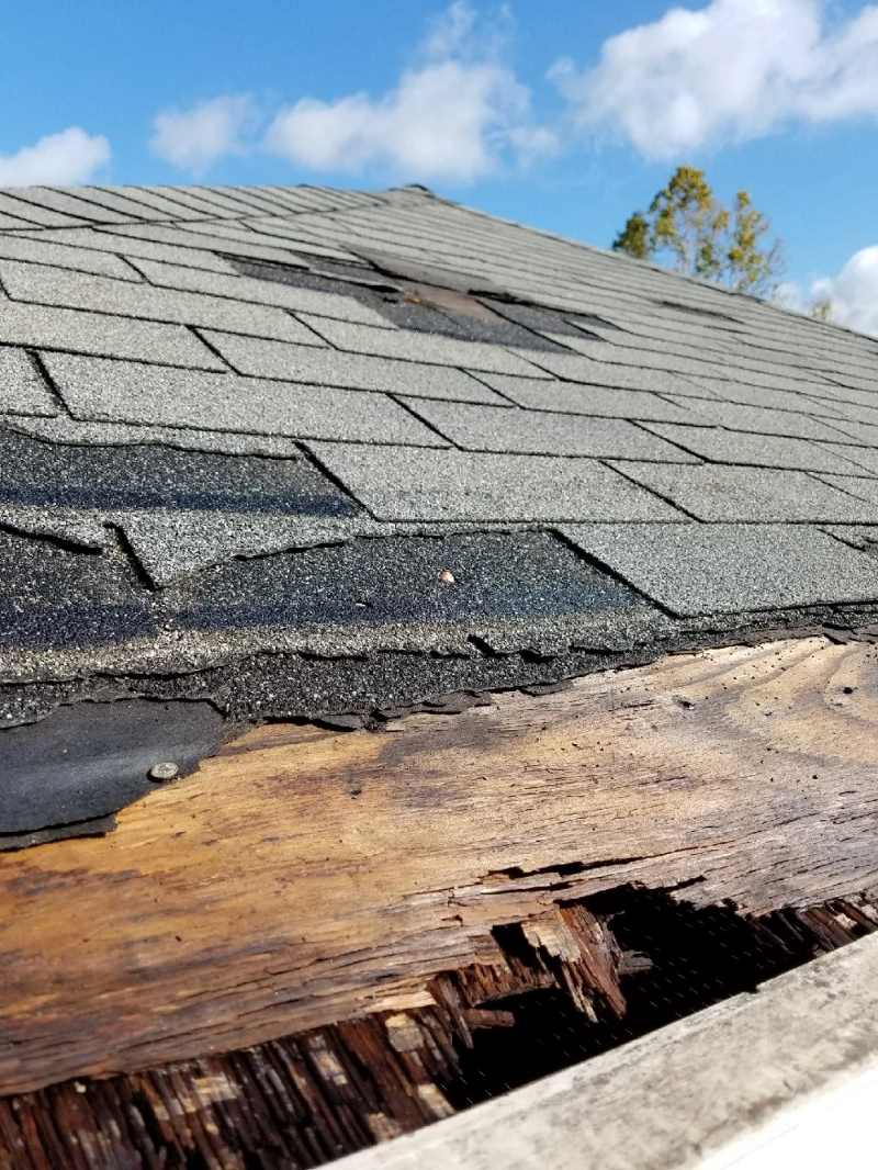 A roof with missing shingles and other damage