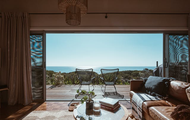 A vacation property looking to a balcony with two chairs in center 