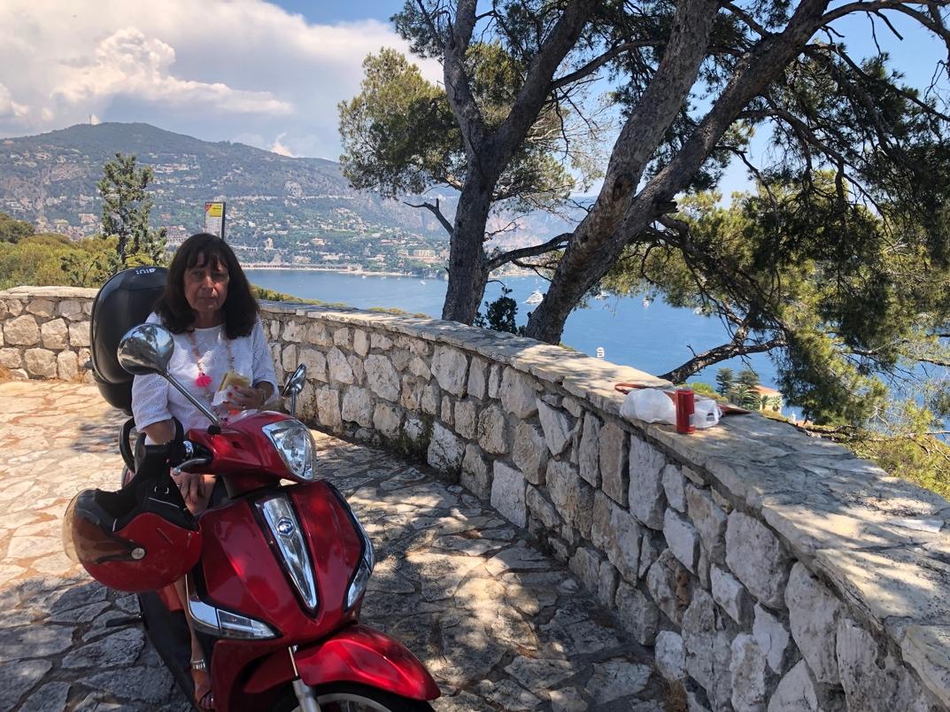 A person on a red scooter

Description automatically generated