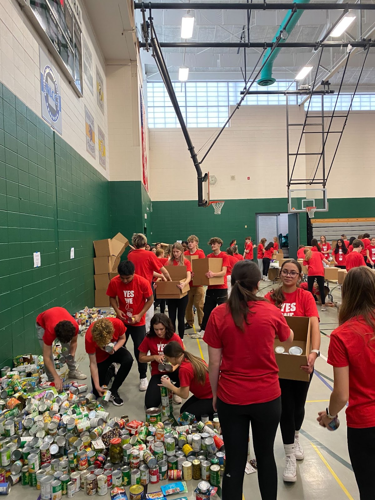 students in red shirts going through donated food