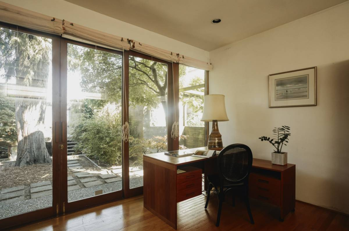 A desk in front of glass panel doors showing a Japanese-inspired garden