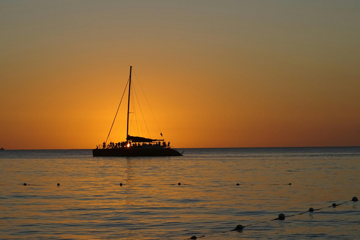 It's sunset time and sky turns into orange color and ship is sailing in the water and people enjoying in the ship