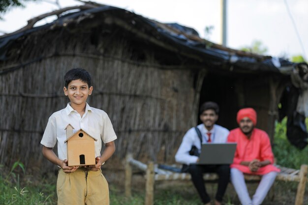 Dream home concept : poor farmer little child holding handmade home in hand