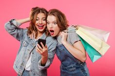 This contains an image of: Free Photo | Shocked two women friends holding shopping bags using mobile phone.