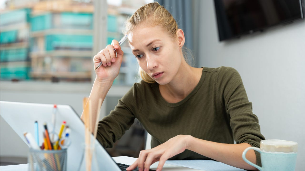 in this image the girl is watching her debts liability on laptop. 