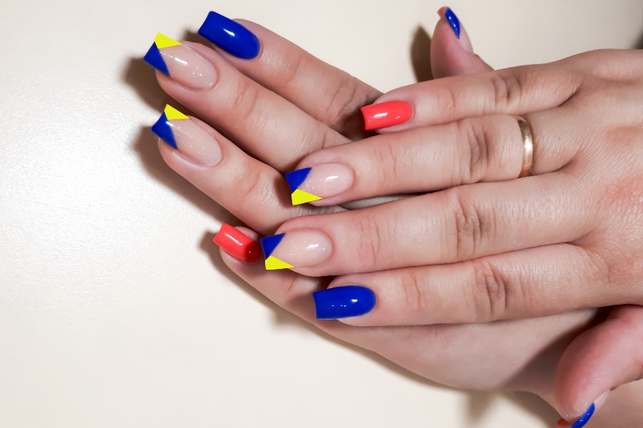 V-shaped tips modernize French nail tip design with sharp, angular edges.