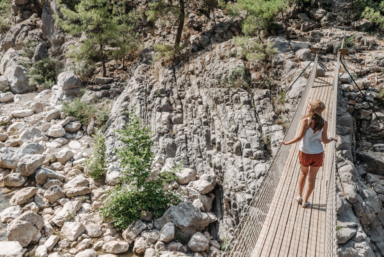 Woman in White Spaghetti Strap Top with Brown Bucket Hat Standing on a Hanging Bridge // Healthier Baby Today