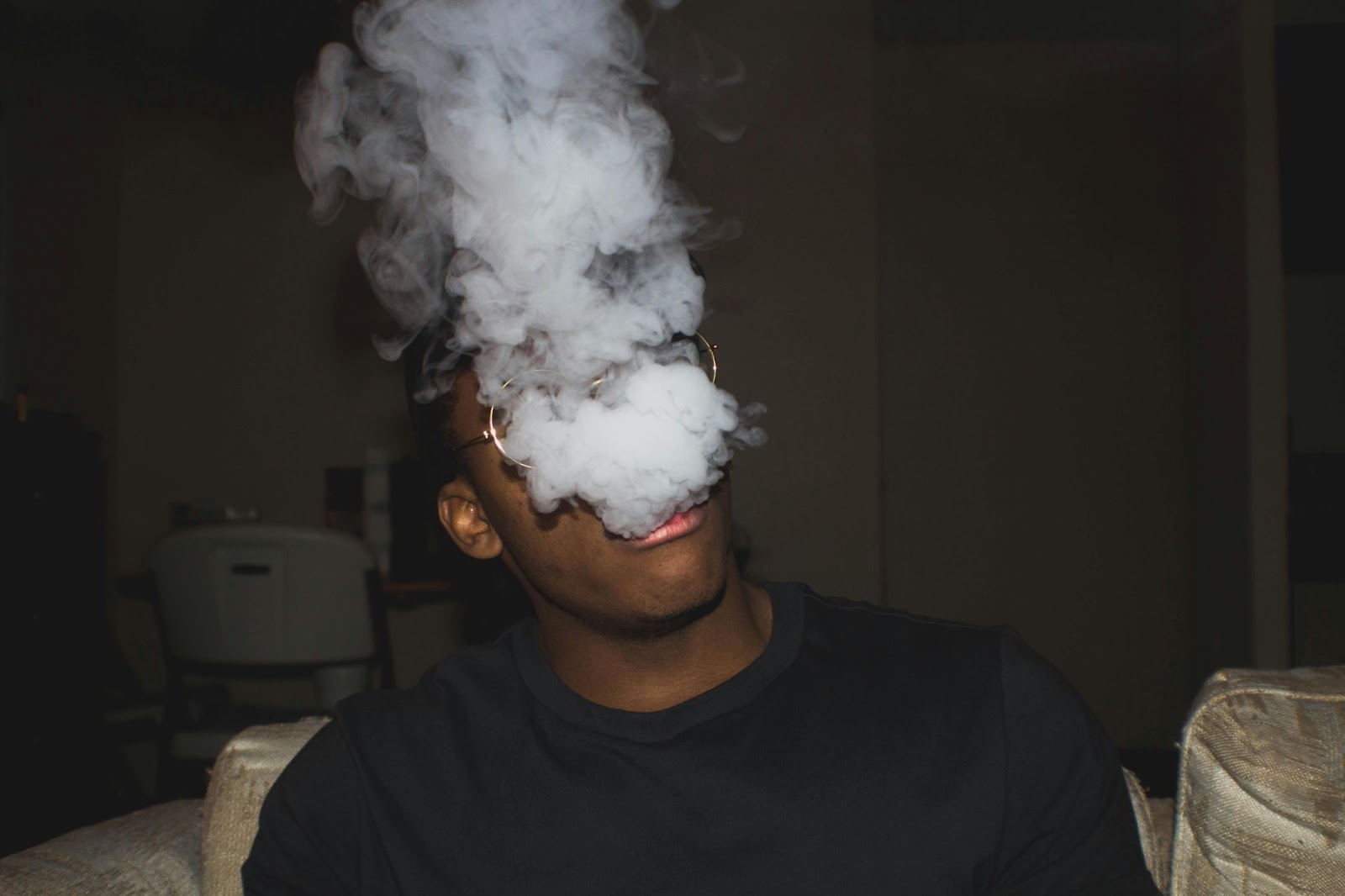  Man Blowing Smoke While Inside His Home