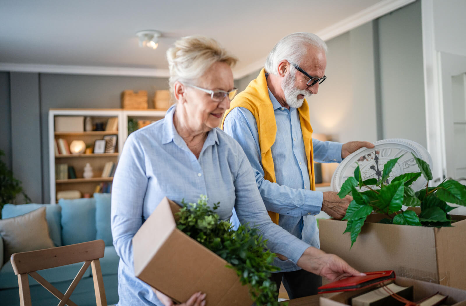 A senior couple smiling while downsizing their home to prepare for a smooth transition to senior living.