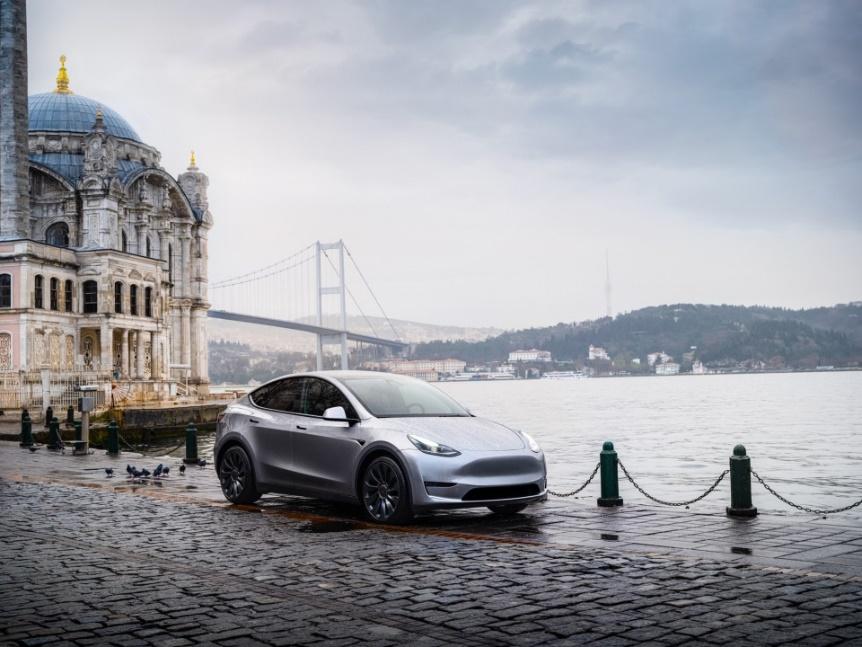 A car parked on a brick road next to a body of water

Description automatically generated