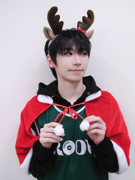 This contain Park Han  wearing reindeer antlers on his head and holding two balls in front of him