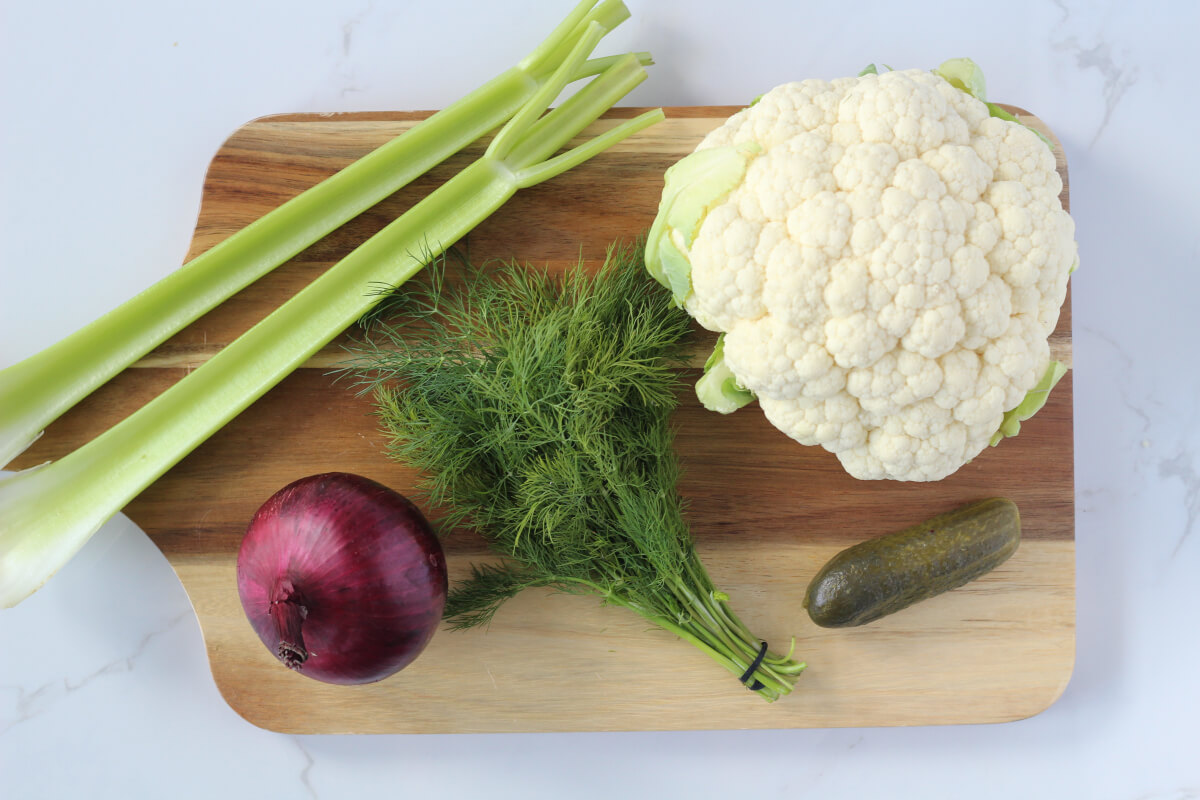 Cauliflower potato salad ingredients on wooden board