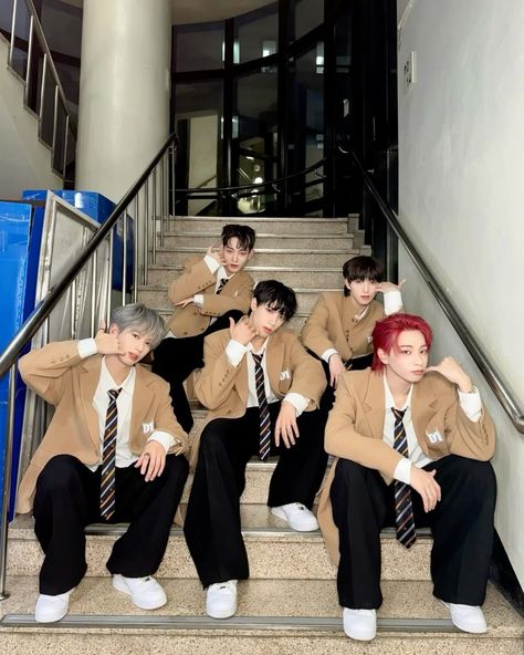 This  contain an image of   DXMON fandom are dressed in suits and ties sitting down on the stairs outside an office building