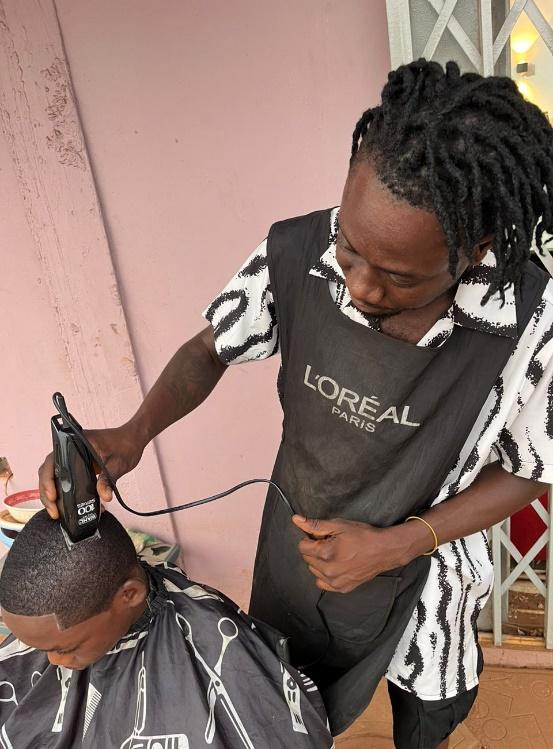 Giving a clean low hair cut to a child from a mobile home delivery service.