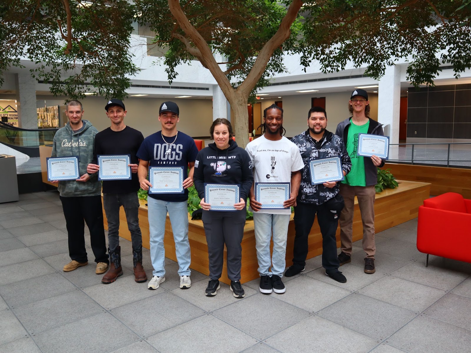 Group of Pinnacle Career Institute graduates holding certificates after completing their hybrid trade school boot camp. PCI students celebrate hands-on training completion in programs like HVAC, wind turbine technician, and tower technician.