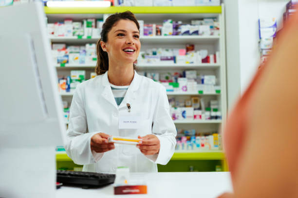 Pharmacist behind the counter at Magnolia Pharmacy discussing L-Theanine supplements with a customer seeking natural ADHD support.