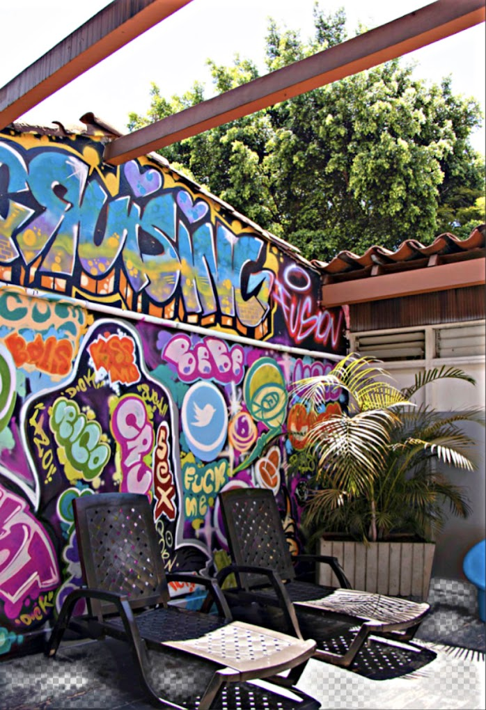 colorful mural that says cruising and fuck me in graffiti paint on the rooftop terrace of Medellin Colombia's gay bathhouse Sauna Cruising
