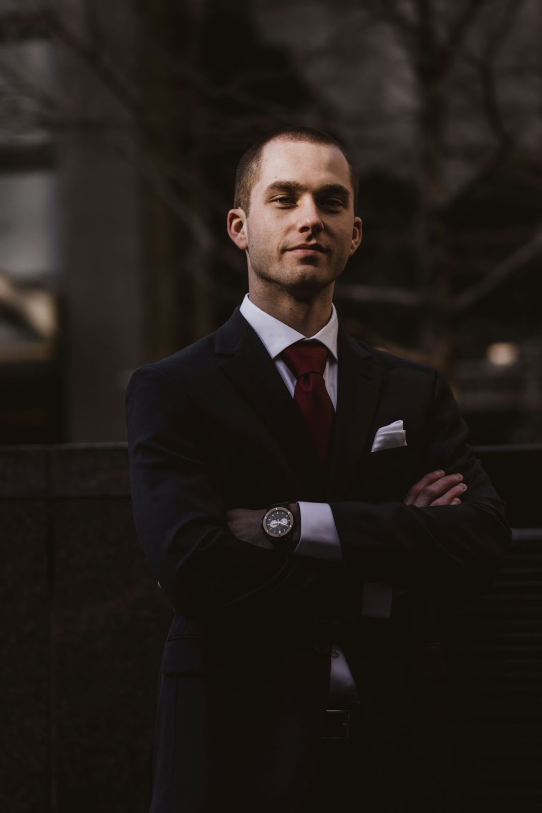 Using a tie for a professional photoshoot: A man wearing a complimenting red tie with a black suit