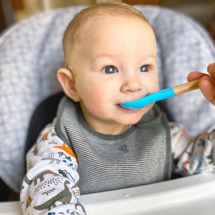 Baby eating with a bamboo and silicone Avanchy spoon.