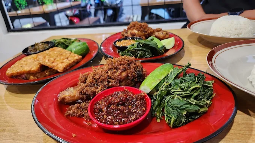 Ayam Goreng Laos Mazprie disajikan dengan sambal pedas, lalapan segar, dan tempe goreng