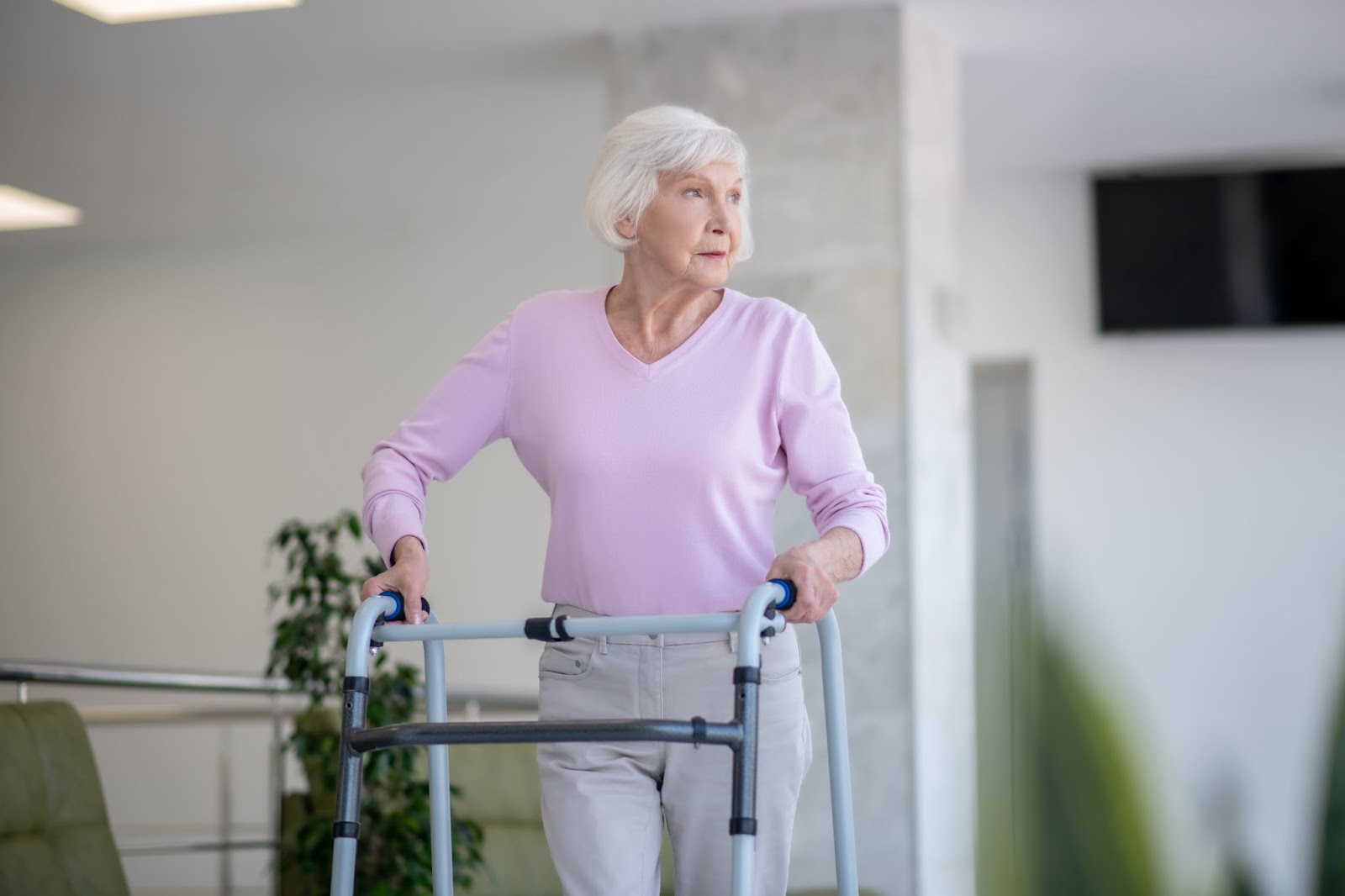 Elderly woman with a rolling-walker looking aside