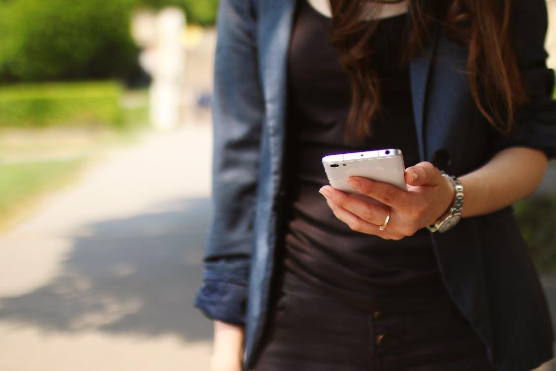 Gratis Mujer Sosteniendo Smartphone Blanco Foto de stock