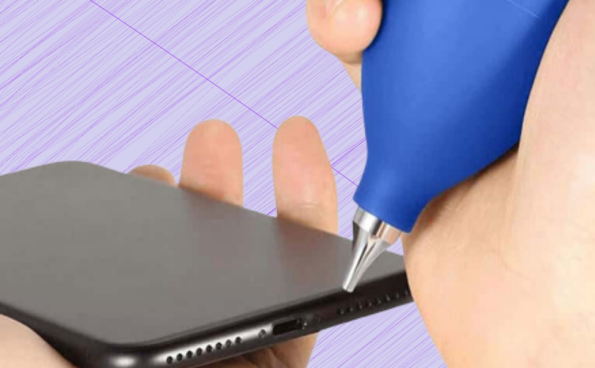 Person cleaning an iPhone port using a blue air blower