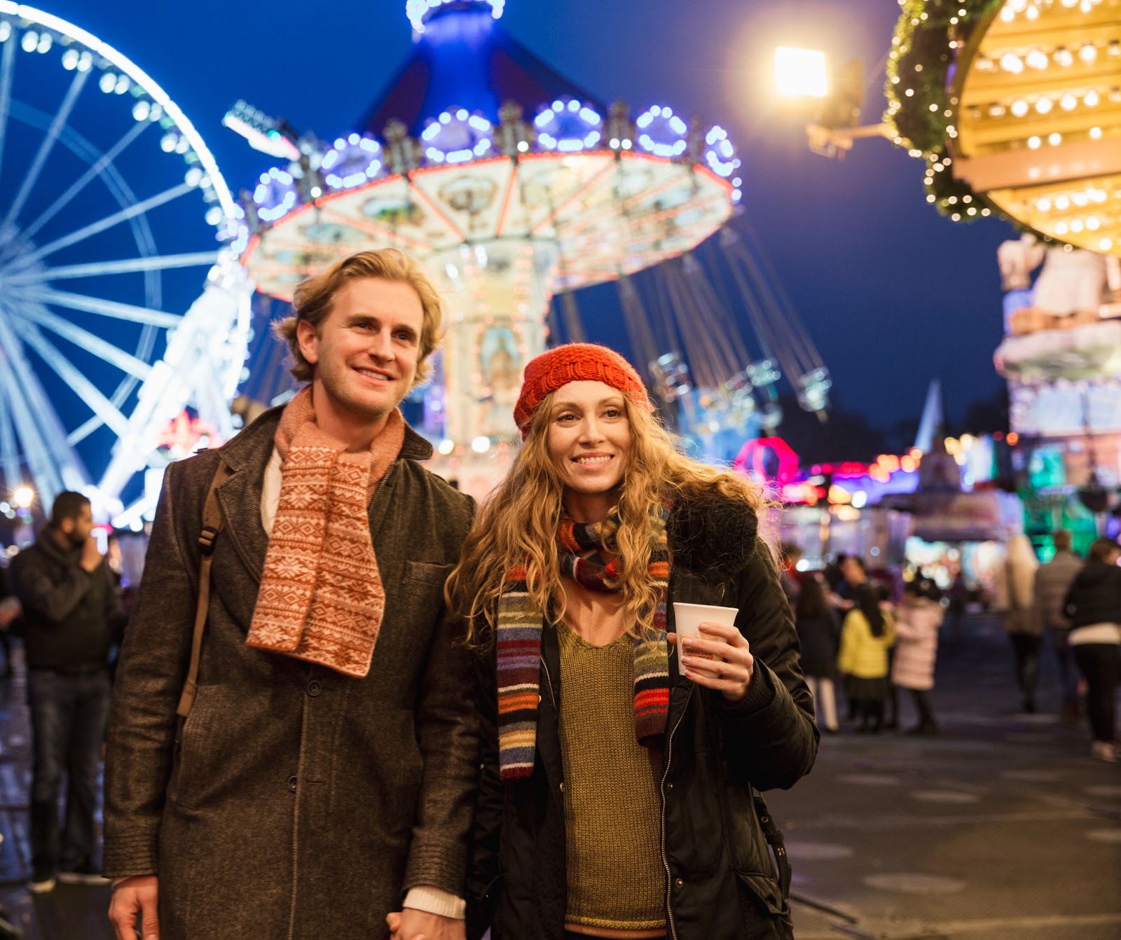 Festive stalls and a brightly lit observation wheel at Winter Wonderland in Hyde Park, London, creating a magical atmosphere