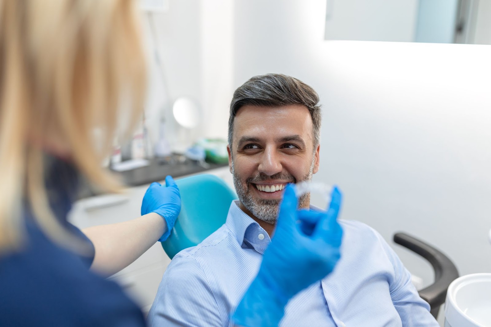 A dentist explains to their patient how to use and care for their Invisalign aligner.