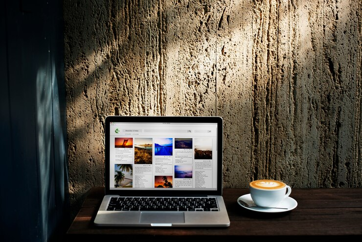 A laptop and a cup of coffee on a bench