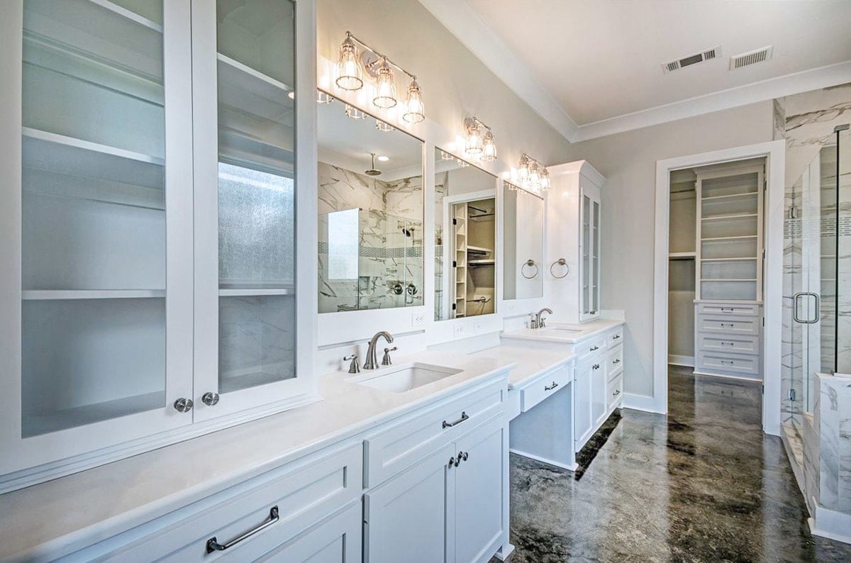 Primary bathroom with dual vanity and a walk-in closet.