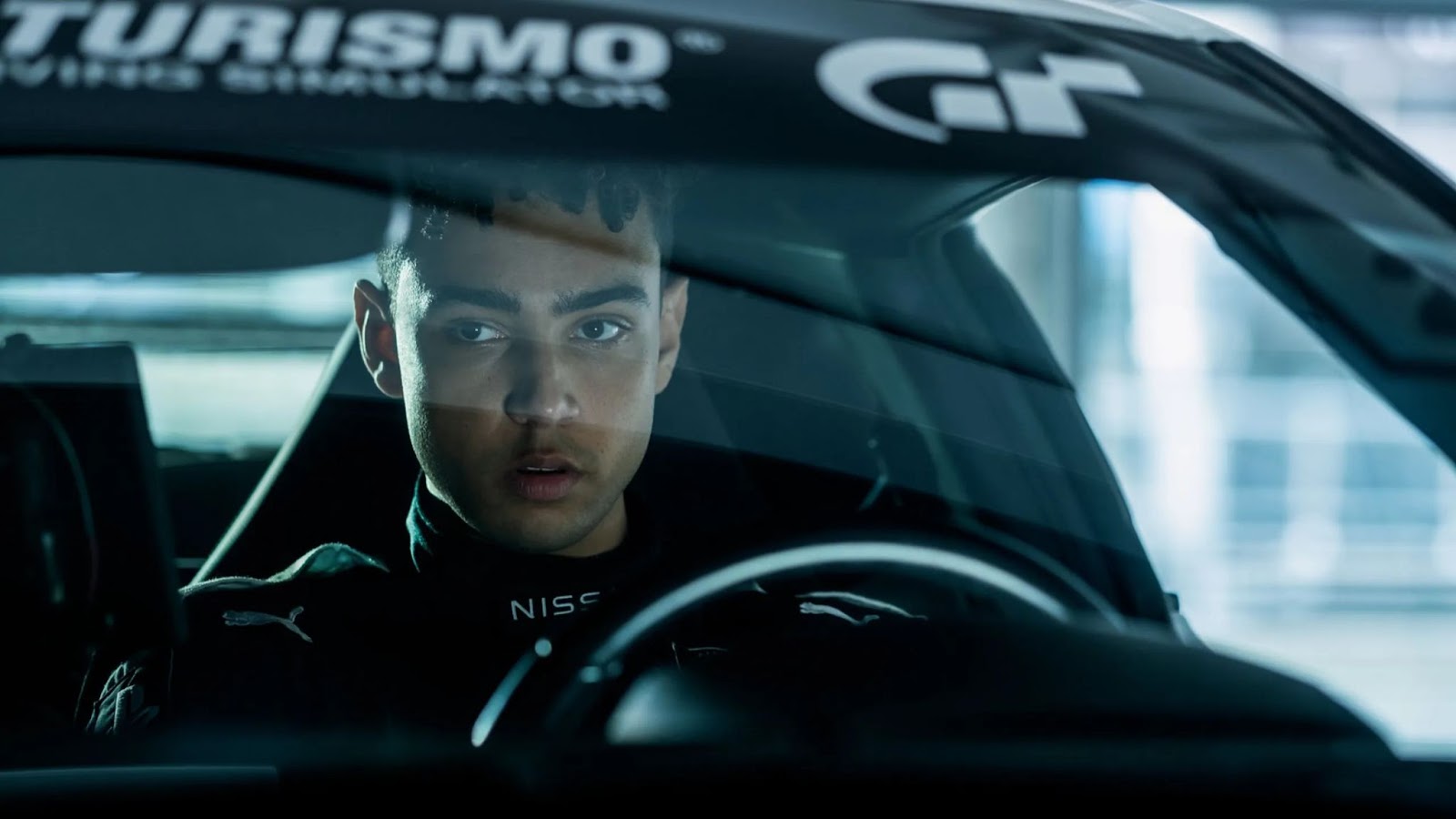 Imagen del protagonista de Gran Turismo a bordo de su automóvil, antes de comenzar una carrera profesional.