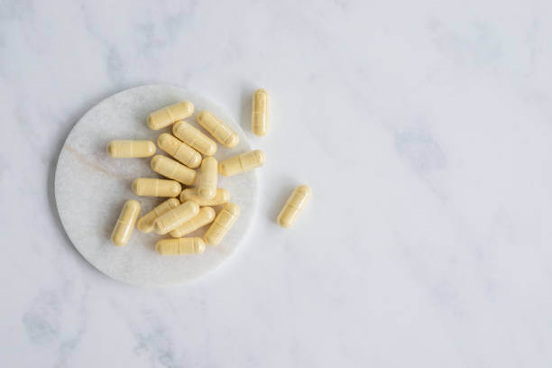 A close-up of several yellow berberine capsules on a small white plate, highlighting their natural supplement form.