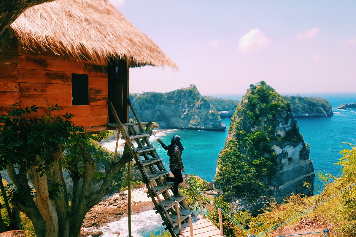 A traveler moving down of the stairs of a treehouse in Nusa Penida island.