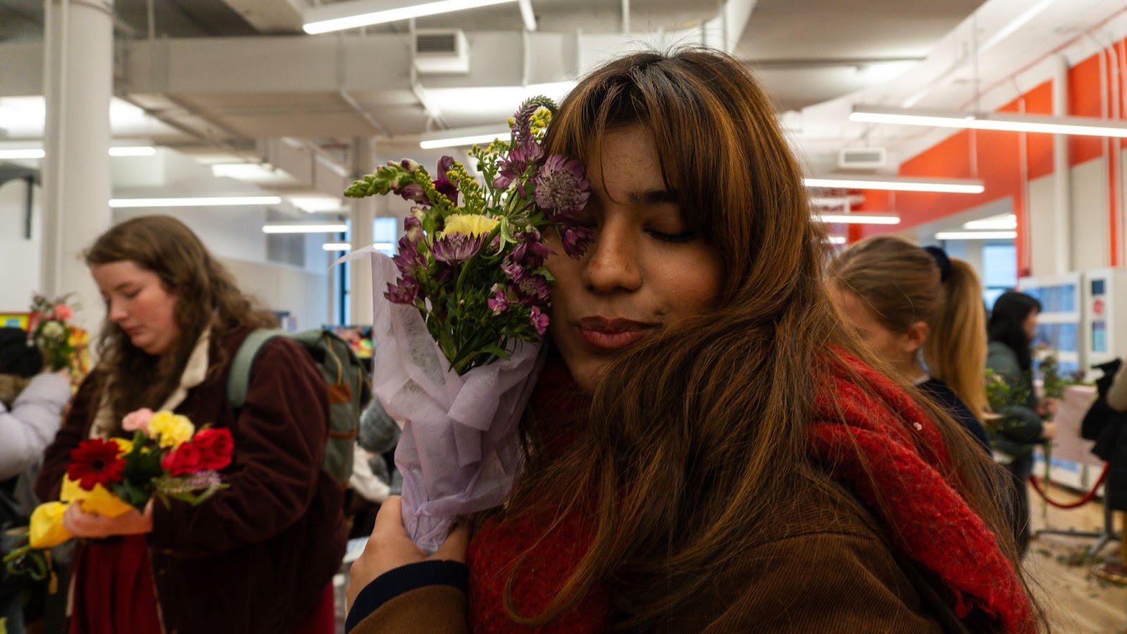 An image of a student, hugging her bouquet.