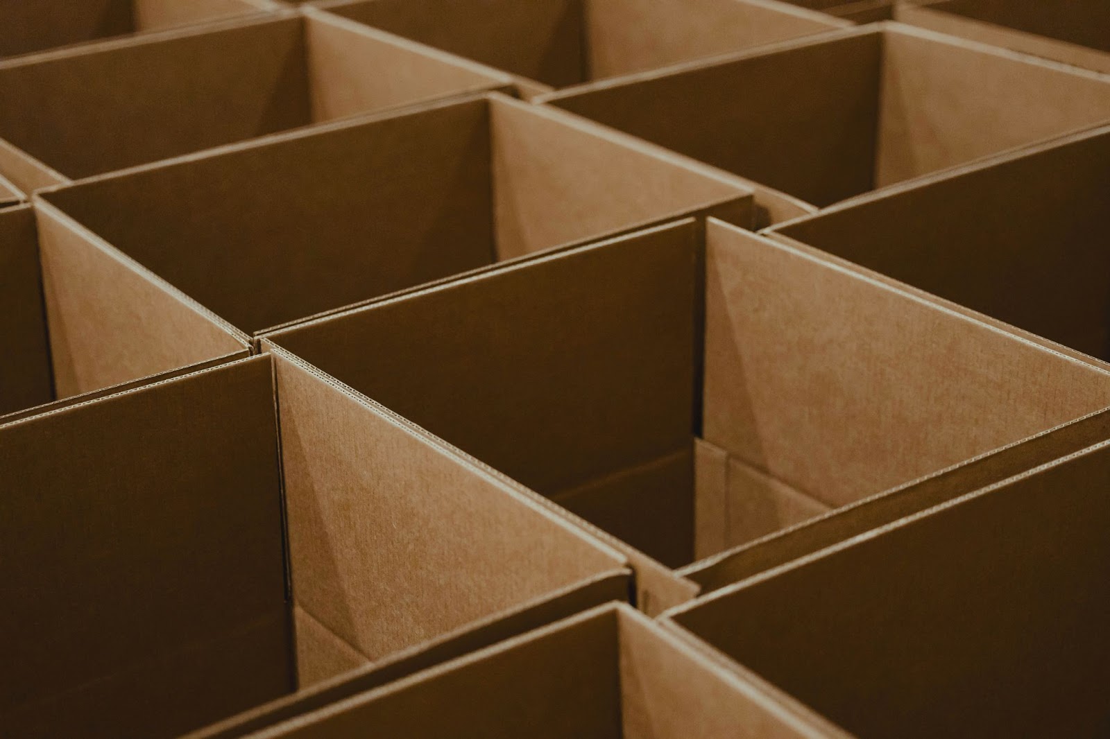 Rows of open, empty cardboard boxes neatly arranged in a grid, ready for packing or shipping purposes.