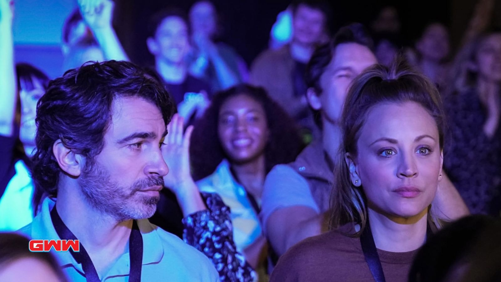 Ava and Nathan Bartlett stands in a crowd at an event, appearing focused and tense.