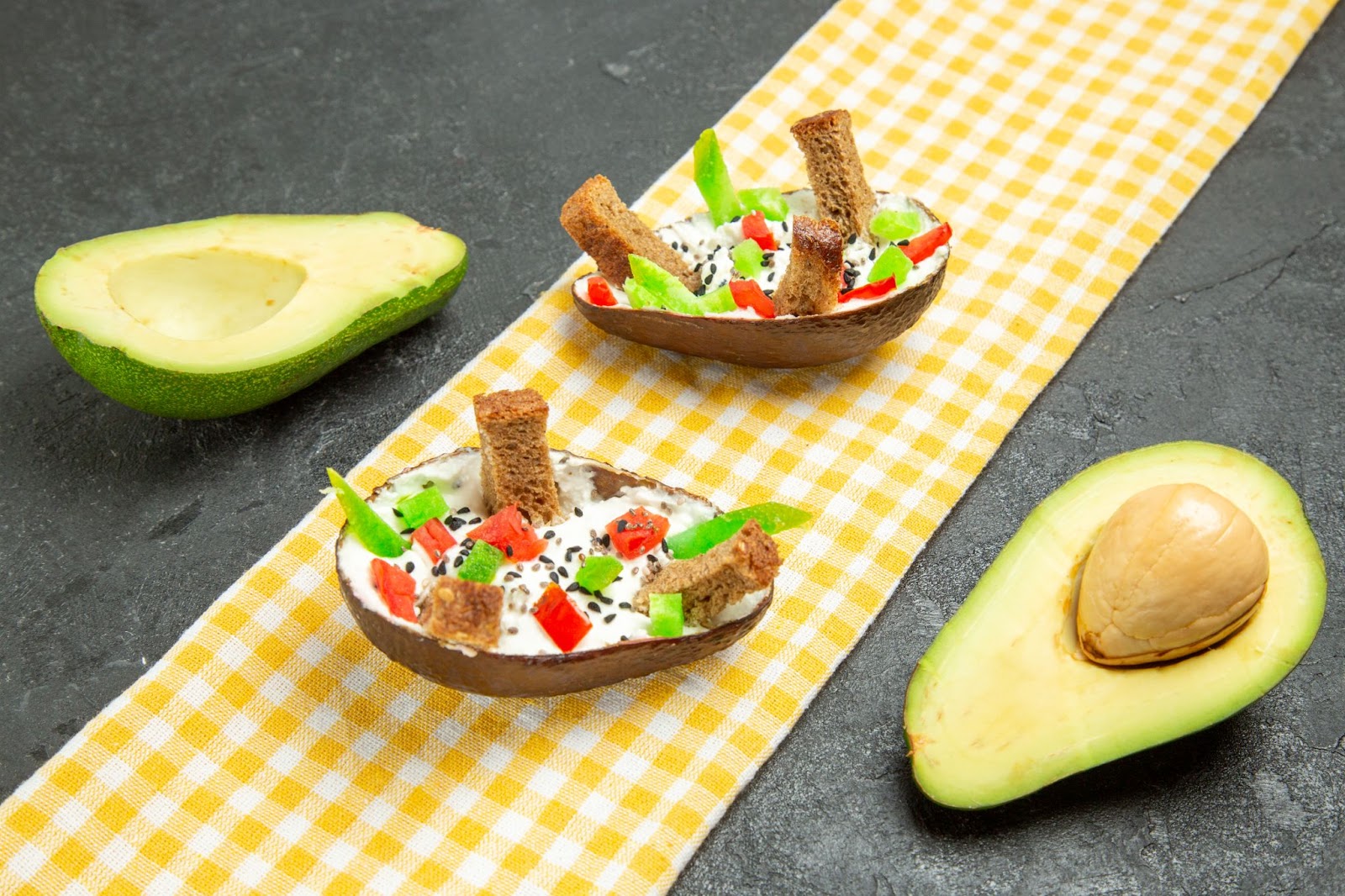 Avocado halves with dip, veggies, and bread sticks&nbsp;