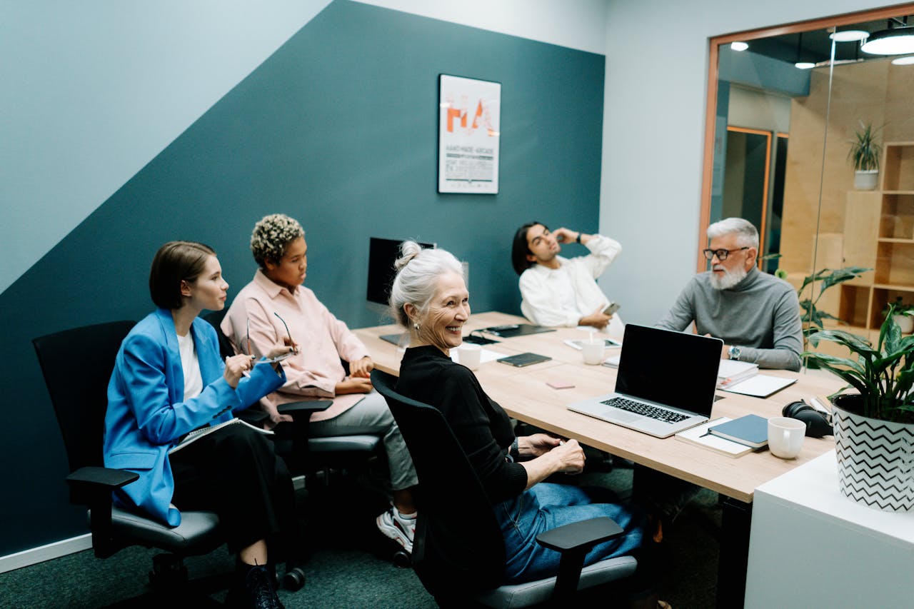 Team members engaged in a meeting in a modern office, discussing strategies and ideas to effectively manage small business operations