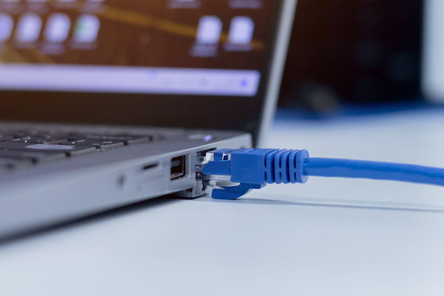 A blue Ethernet patch cable connected to a laptop PC
