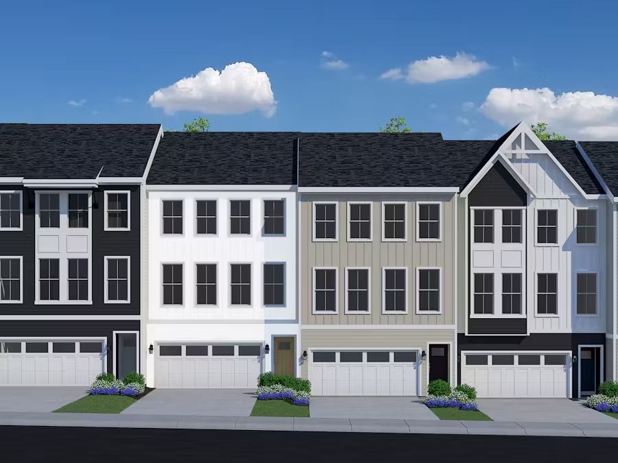 A row of newly constructed three-story townhomes with attached garages, featuring a mix of black, white, and beige exteriors