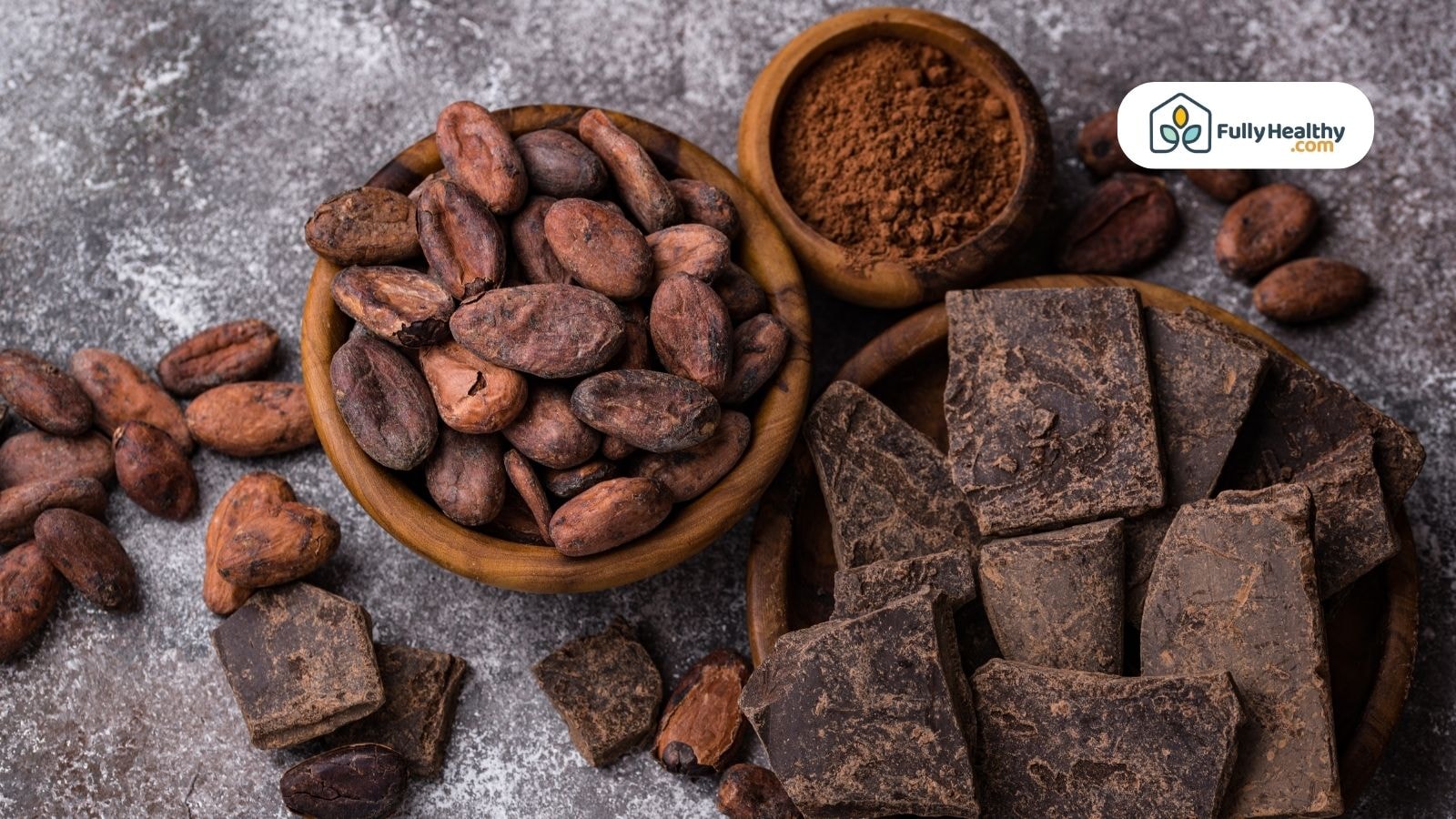 Bowl of cacao beans cocoa powder and chocolate chunks on table