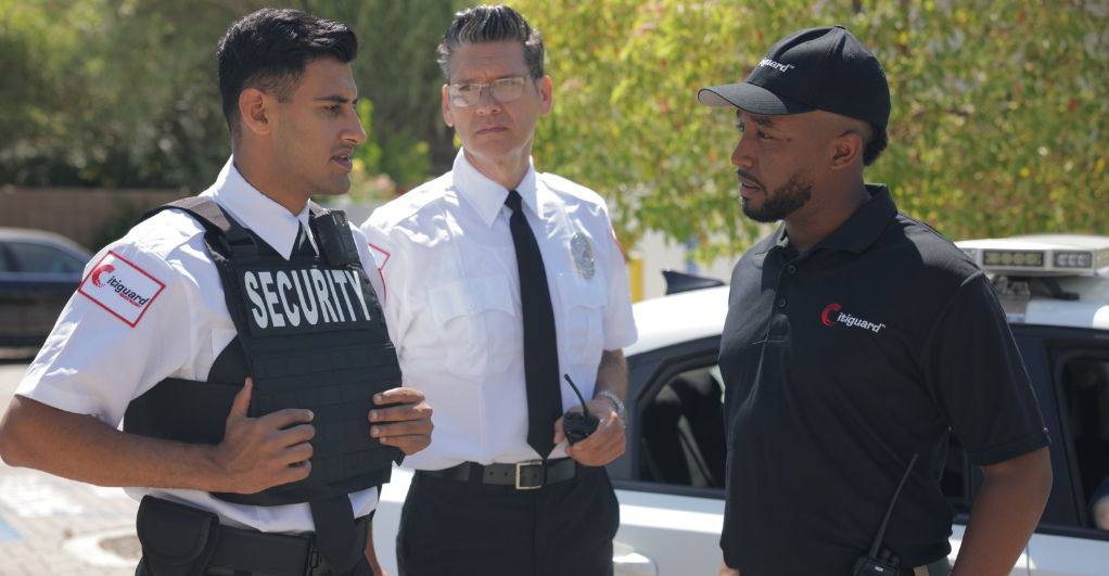 (Three security professionals from Citiguard engage in a tactical discussion near a patrol vehicle, demonstrating coordination and readiness in field operations.)