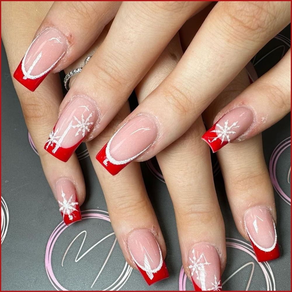 Close up of hands having Christmas red nails with Red French Tips with a Festive Twist