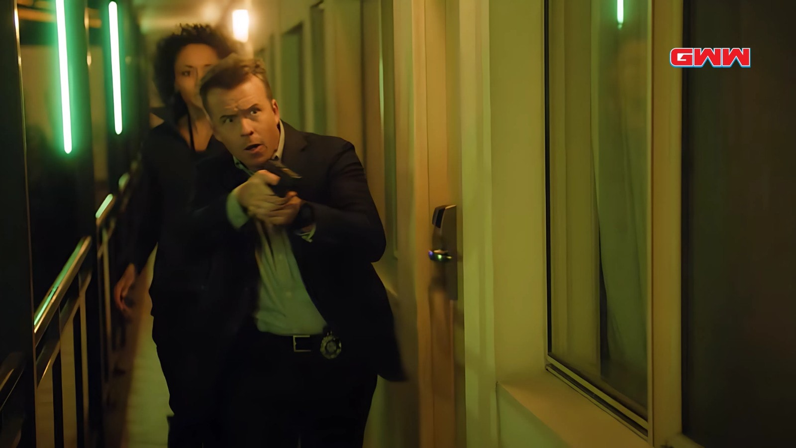 Todd Lasance and Olivia Swann during a dangerous hallway pursuit